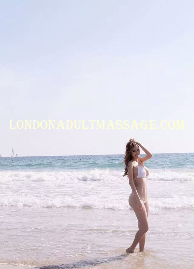 A professional photograph taken of independent escort Tiffany Gong posing in a beach swimsuit.